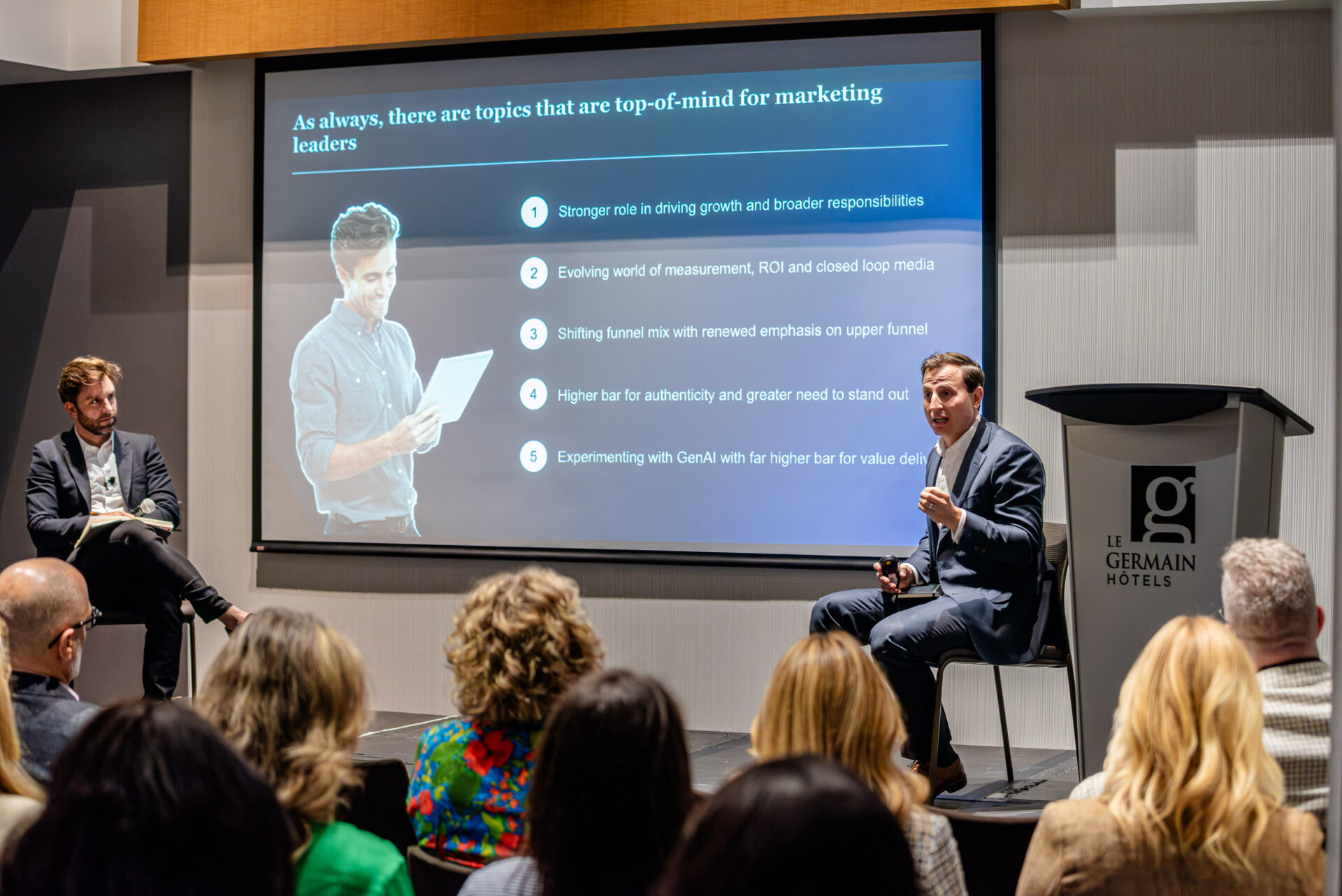 McKinsey partners presenting insights to the audience at the C-Suite Marketing Summit.